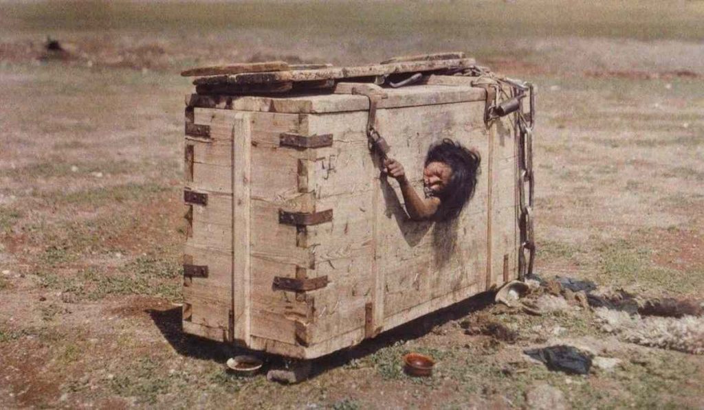 A Mongolian woman is confined in a wooden box as punishment